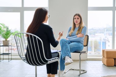 Genç bir kadın için profesyonel psikolojik destek. Hasta ve kadın terapist danışman sosyal hizmet görevlisi konuşması, terapi seansı. Psikoloji, psikoterapi, danışmanlık, ruh sağlığı hizmetleri.