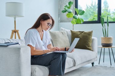 Merkez ofiste bilgisayarla çalışan orta yaşlı ciddi bir kadın, kanepede oturuyor. Kendine güvenen olgun bir kadın not alıyor, iş ödemeleri üzerine serbest meslek eğitimi alıyor.