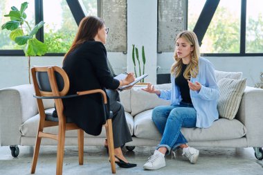 Psikolojik terapide genç bir kadın profesyonel ruh sağlığı terapistiyle konuşuyor. Yardım, tavsiye, destek, tedavi, sosyal hizmetler, psikoloji, psikoterapi ve gençlik danışmanlığı