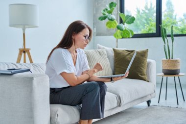 Merkez ofiste bilgisayarla çalışan orta yaşlı ciddi bir kadın, kanepede oturuyor. Kendine güvenen olgun bir kadın not alıyor, iş ödemeleri üzerine serbest meslek eğitimi alıyor.