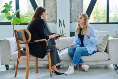 Psikolojik terapide genç bir kadın profesyonel ruh sağlığı terapistiyle konuşuyor. Yardım, tavsiye, destek, tedavi, sosyal hizmetler, psikoloji, psikoterapi ve gençlik danışmanlığı