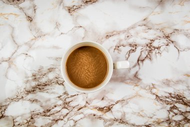 Beyaz fincanda kahve, mermer arka planda.