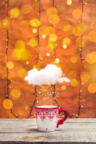 Kar bulutlu tatil kupası ve ahşap bir masanın üzerinde bokeh ışıkları