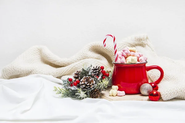 Roter Becher Mit Marshmallows Und Winterschmuck Auf Weißem Laken — Stockfoto
