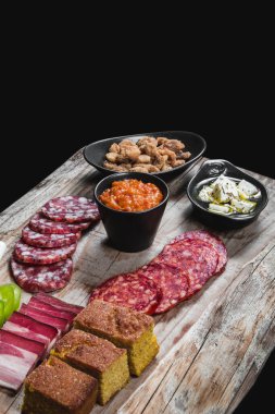 Kuru et ve sosis, sebze ve peynirle ahşap bir masada.