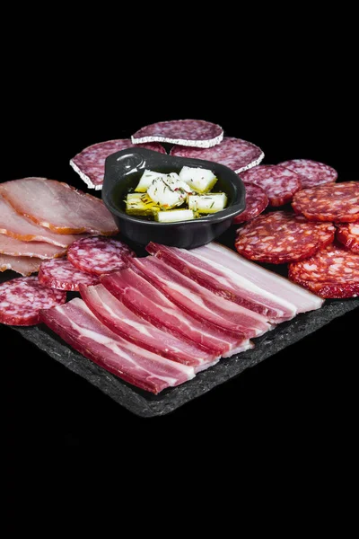 Trockene Fleisch Und Wurstsorten Auf Schwarzem Teller Und Hintergrund Stockbild