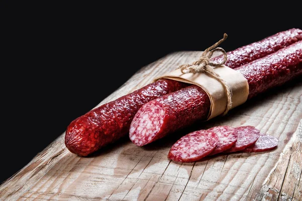 Trockenfleischwurst Auf Einem Holzteller Mit Gemüse lizenzfreie Stockfotos