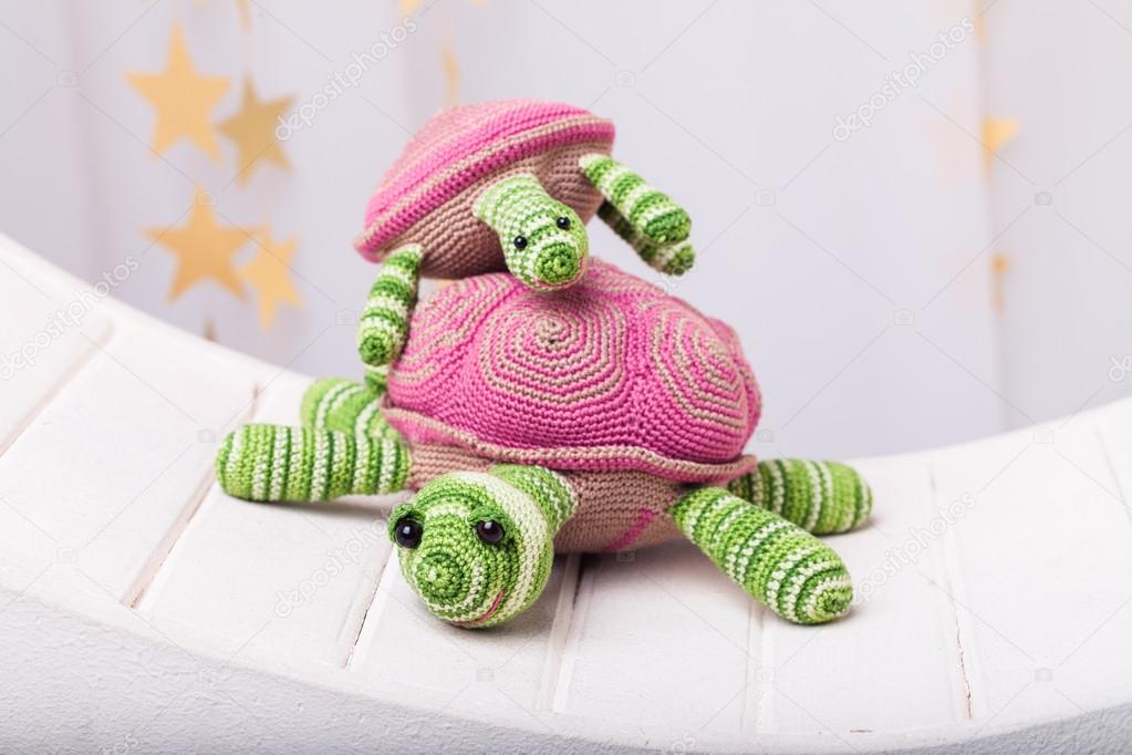 two pink crocheted turtles on light background