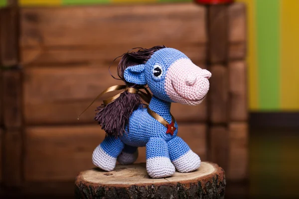 Blue crocheted horse on wooden background — Stock Photo, Image