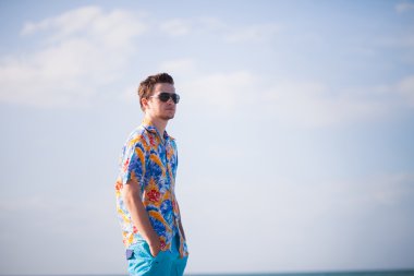 young man in sunglusses on the seacost