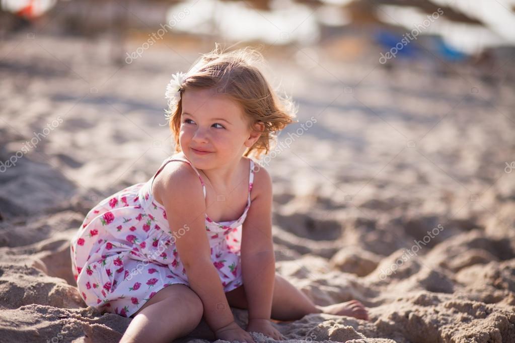 Little Blond Girl With Blue Eyes On The Beach Near The Sea Stock