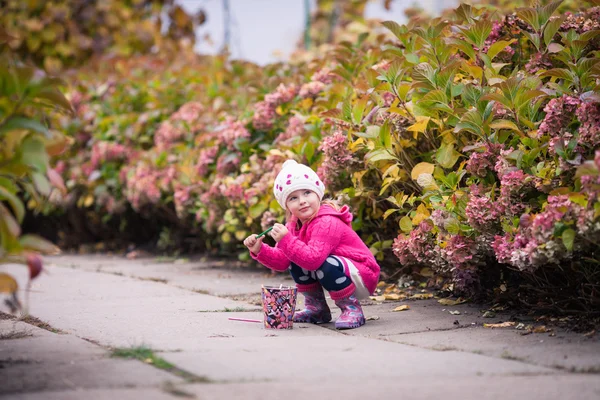 Kleines Mädchen im herbstlichen Garten — Stockfoto