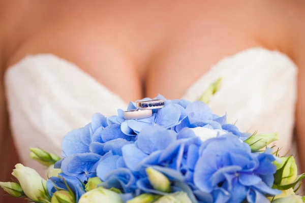 Anillos de boda en las flores azules Imágenes de stock libres de derechos