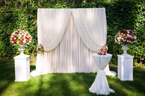 wedding arch with flowers on the green leaves background