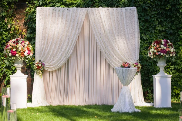 Arco de casamento com grandes buquês de flores nas folhas verdes backgr — Fotografia de Stock