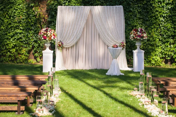 Matrimonio arco con mazzi di fiori grandi sul retro foglie verdi — Foto Stock