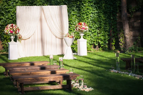 wedding arch with flowers on the green leaves background