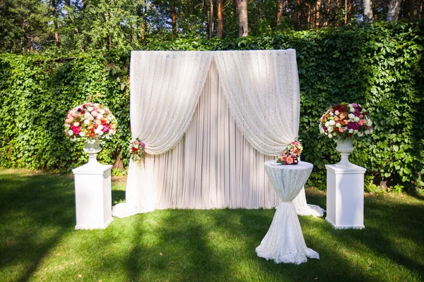 Matrimonio arco con mazzi di fiori grandi sul retro foglie verdi Foto Stock Royalty Free