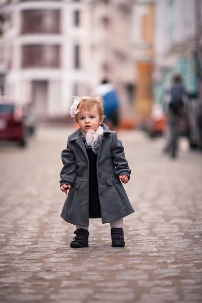 Una pequeña dama de pie en la calle — Foto de Stock