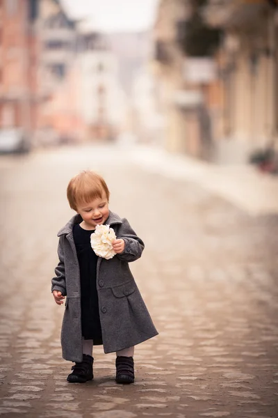 Una pequeña dama de pie en la calle — Foto de Stock