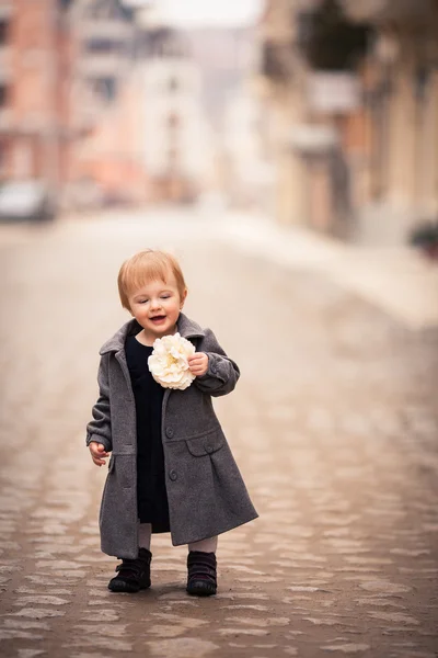 A little lady stand straight on the street