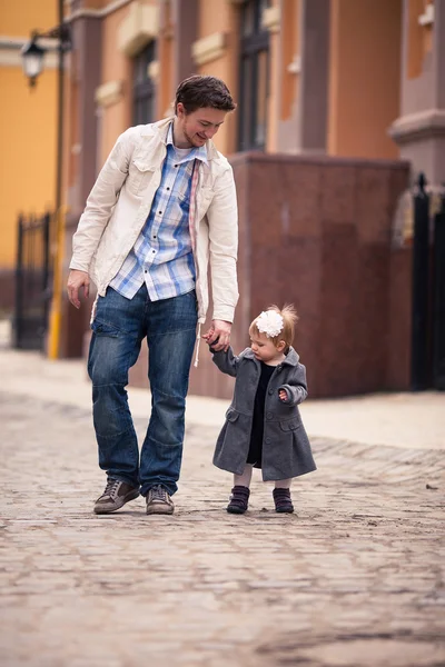 Pappa håller sin dotters hand på gatan — Stockfoto
