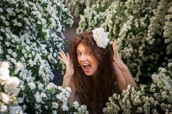 Vacker ung dam i vår trädgård full av vita blommor — Stockfoto