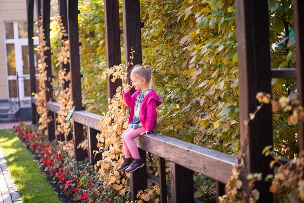 Smiling funny little girl in bright clothes picking her nose — Stock Photo, Image