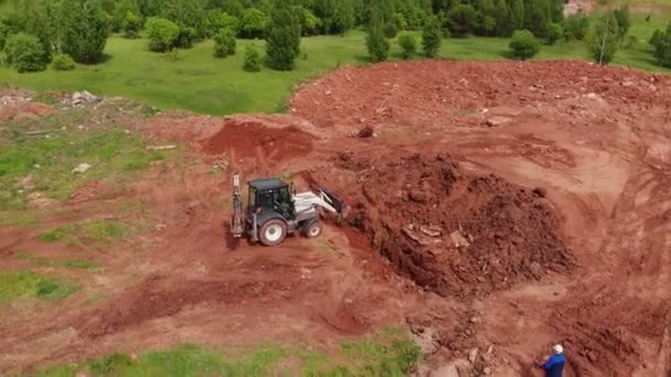 Escavadeira enterra trincheira com sujeira no local de construção — Vídeo de Stock