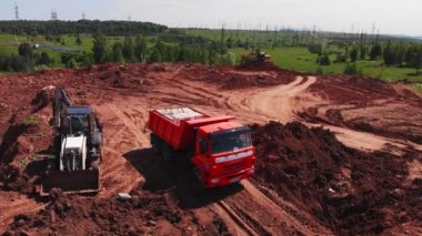 İnşaat alanındaki işçilere kargo taşıyan bir kamyon.