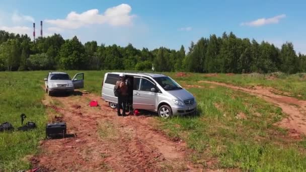 Medewerkers staan bij grijs busje op open bouwplaats — Stockvideo