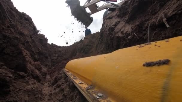 La saleté tombe du seau dans la tranchée avec tuyau dans le boîtier — Video