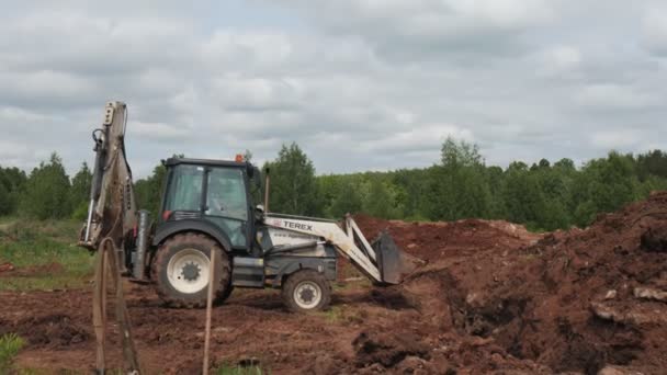 Bulldozer derrama chão em trincheira no local de construção — Vídeo de Stock