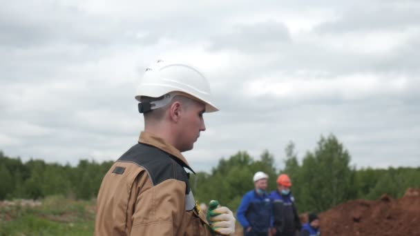 Joven empleado en casco con pala en obra — Vídeo de stock