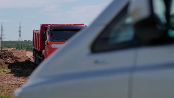 Gran camión volquete rojo y furgoneta en obra abierta — Vídeos de Stock