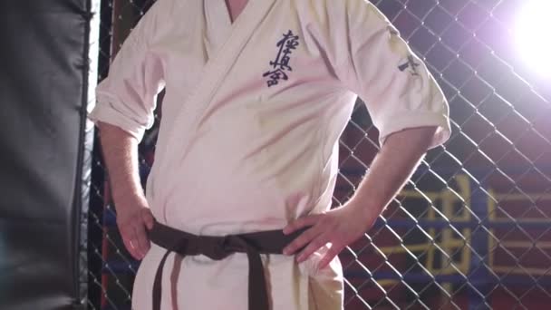 Unavený sportovec v kimonu odpočívá po karate boji na kluzišti — Stock video