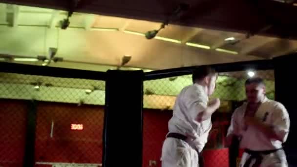 Sportler in Kimonos trainieren Kampf auf großer Eisbahn in Turnhalle — Stockvideo