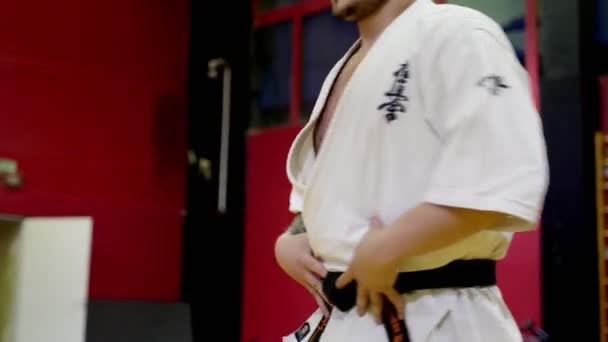 Karatetrainer im Kimono erklärt Schülern Übung — Stockvideo