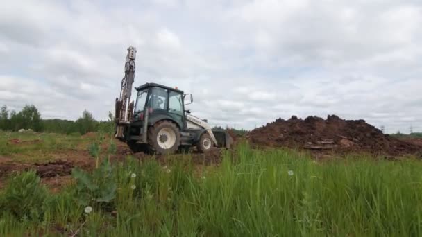 Excavatrice enterre tranchée profonde avec tuyau sous le contrôle des travailleurs — Video