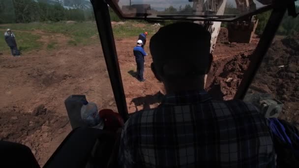 Wykwalifikowany pracownik prowadzi koparkę na placu budowy — Wideo stockowe