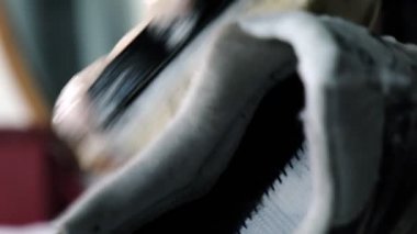 Eski ayakkabıları atölyede köpüklü fırçayla yıkayan kişi