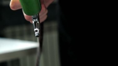 Adam yeşil boyayı arka planda bulanık fırçayla püskürtür.