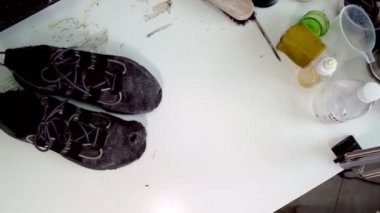 Yenilenmiş ayakkabıları kirli paçavraların yanına koyuyor.