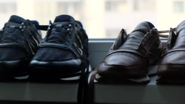 Σετ από αθλητικά παπούτσια και παπούτσια για γέρους χωρίς κορδόνια κοντά στο παράθυρο — Αρχείο Βίντεο
