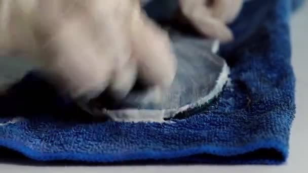 Рабочий убирает пену с кровати с полотенцем за столом — стоковое видео