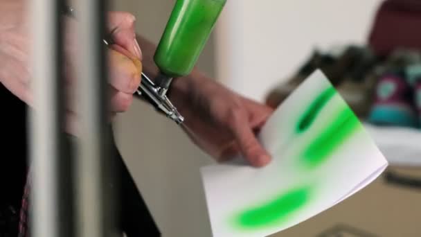 Az ember zöld festéket permetez papírra, hogy ellenőrizze a színt a boltban — Stock videók