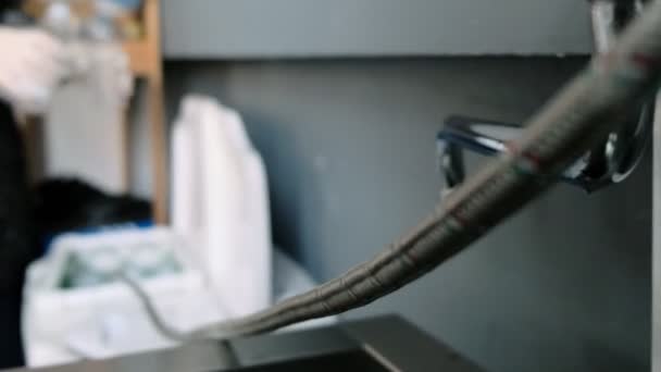 더러운 앞치마를 입고 일하는 사람이 세탁기에 세제를 붓는다 — 비디오