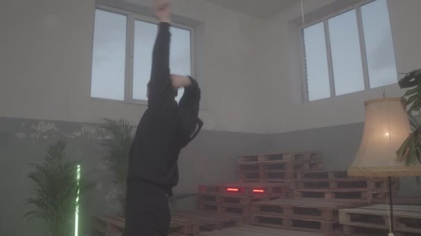 Flexibler Mann im Trainingsanzug tanzt tektonisch in halbdunklem Club — Stockvideo