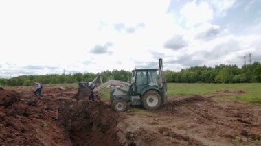 Kazıcı inşaat sahasına çukur kazmak için toprak döker