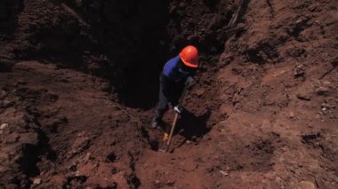 Yetenekli işçiler siperdeki sarı borunun üzerinde çukur kazıyor.